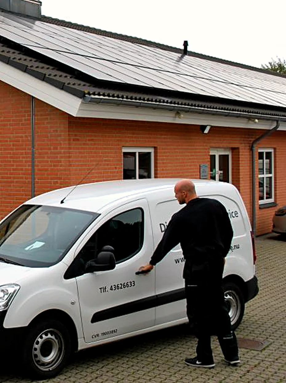 Tekniker fra Din Hvidevare Service ved servicebilen foran værkstedet